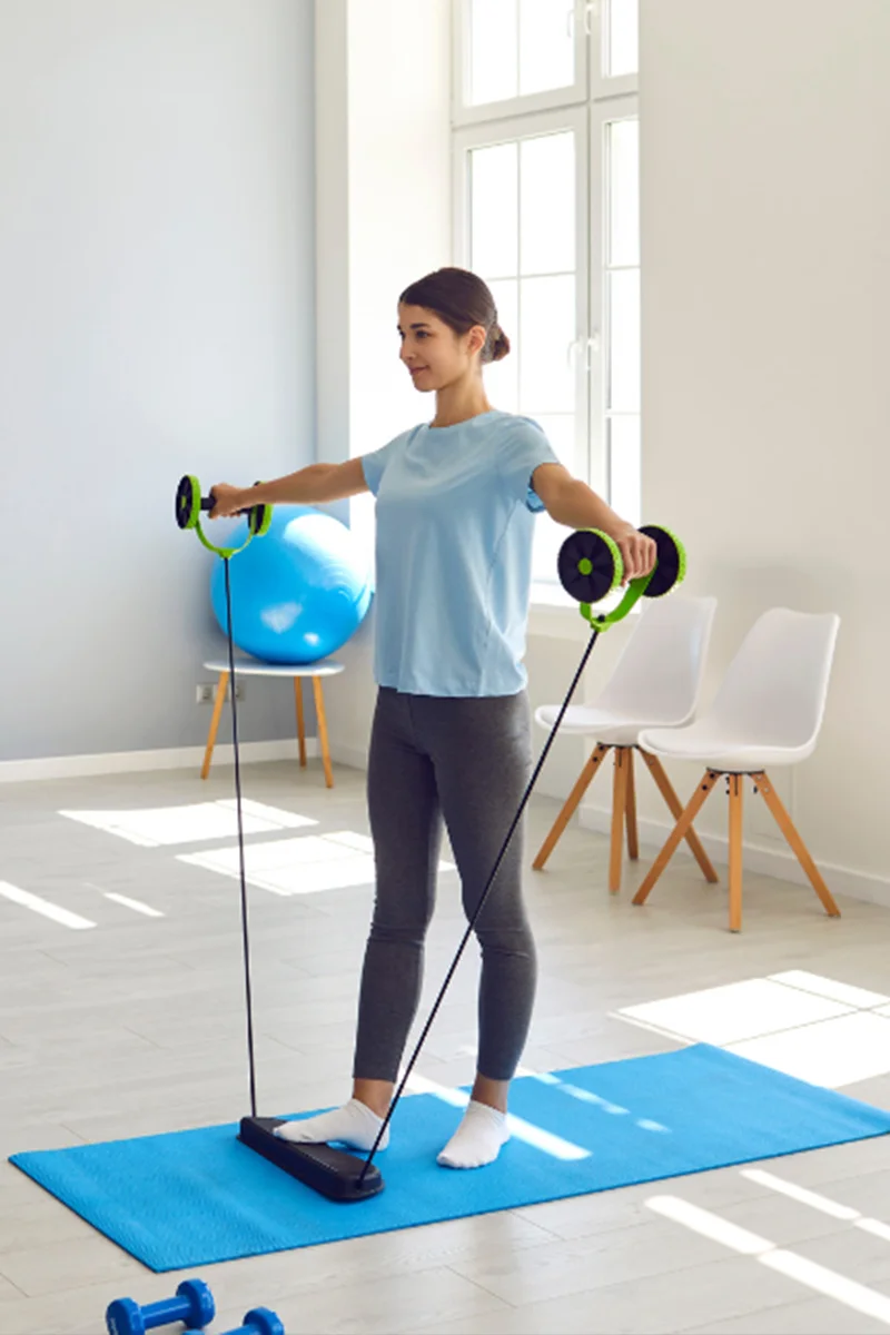 Fizioterápia felsővégtagi műtét után: nő váll- és könyökerősítő gyakorlatokat végez egy gyógytornász irányításával.