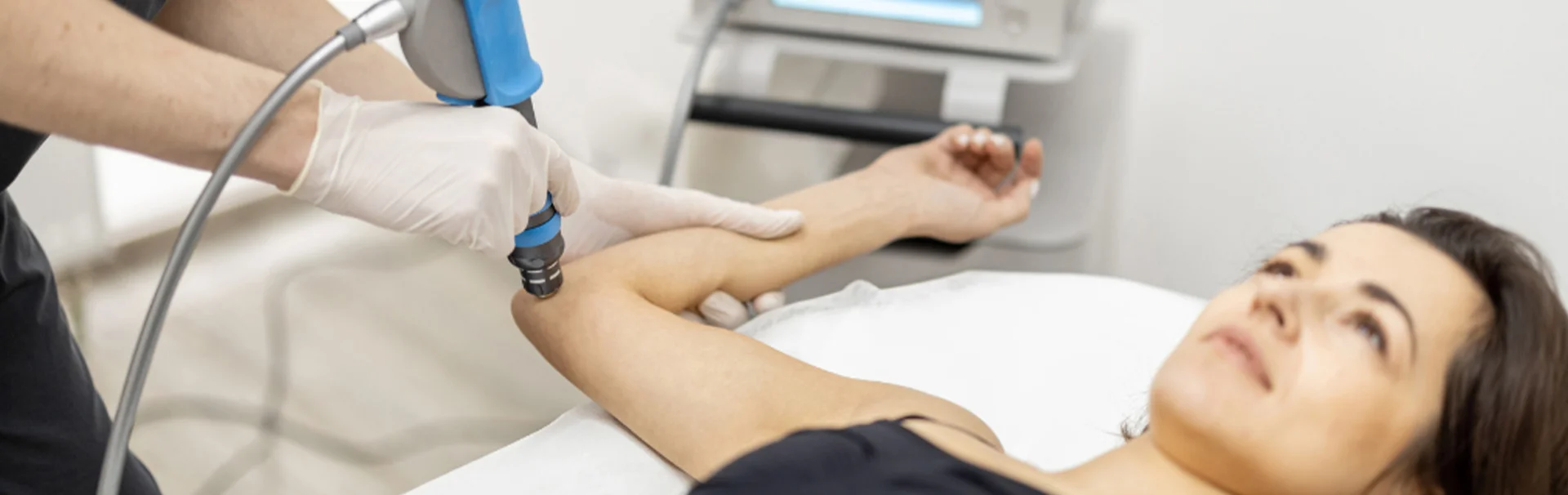 Fizioterápia teniszkönyök kezelésére: gyógytornász segít egy nőnek a könyök panaszok enyhítésében.