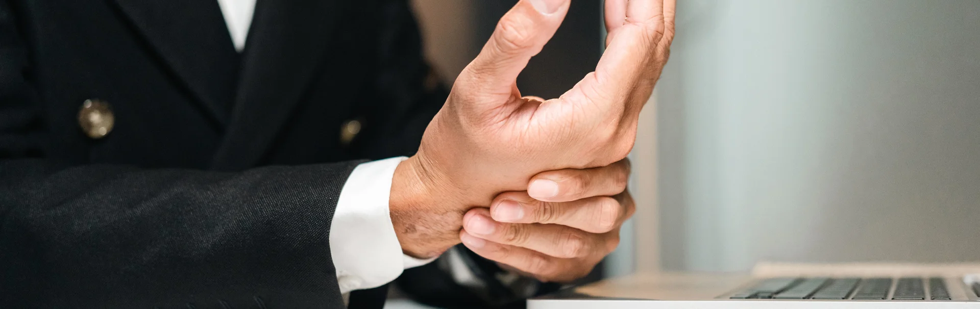 Egy középkorú férfi a csuklóját fogja, miközben kézzsibbadást vagy kézfájdalmat tapasztal